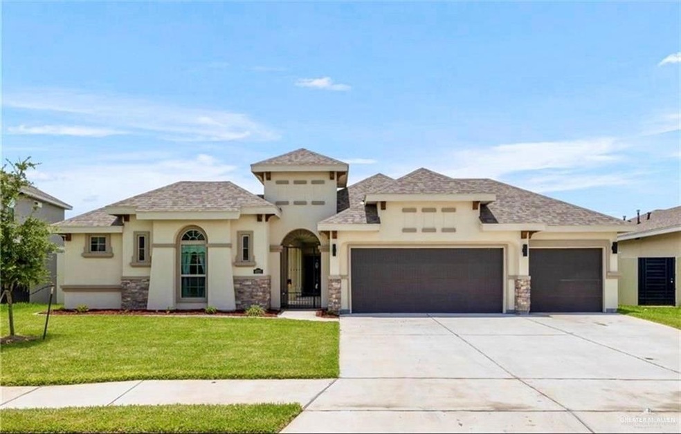 View of front of property featuring a front lawn and a garage