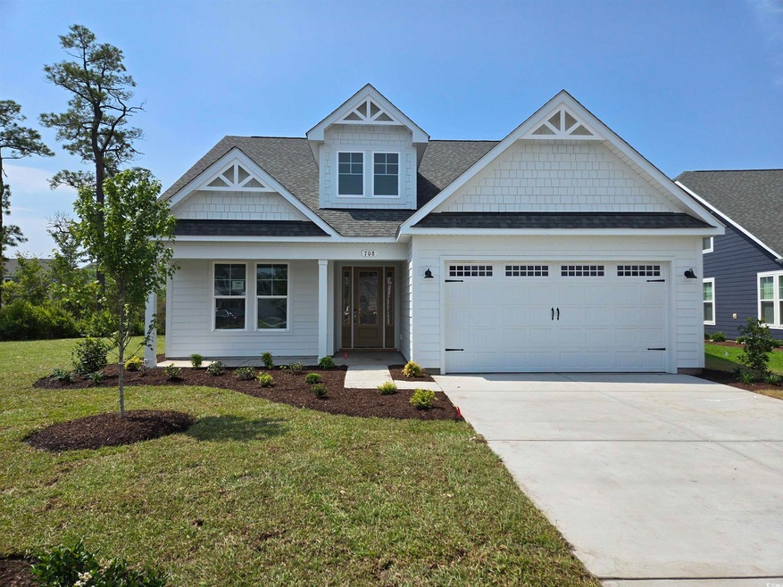 View of front of house with an attached garage, driveway, a shingled roof, and a front lawn