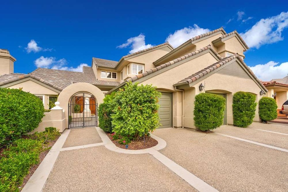 Well manicured entrance with two car garage and a 