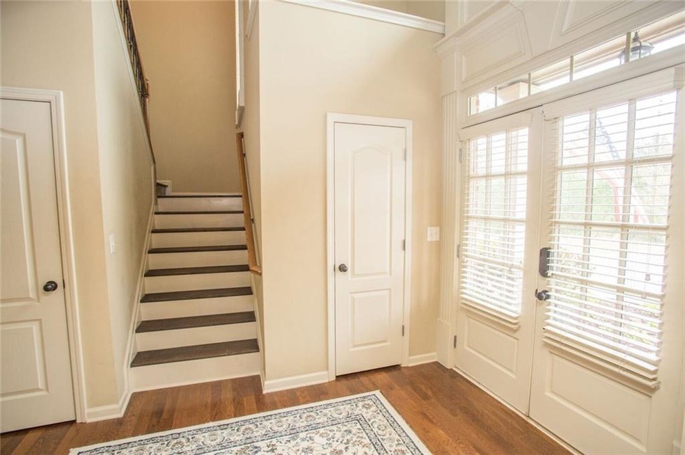 Bright and cheery foyer with french doors and beautiful hardwoods!
