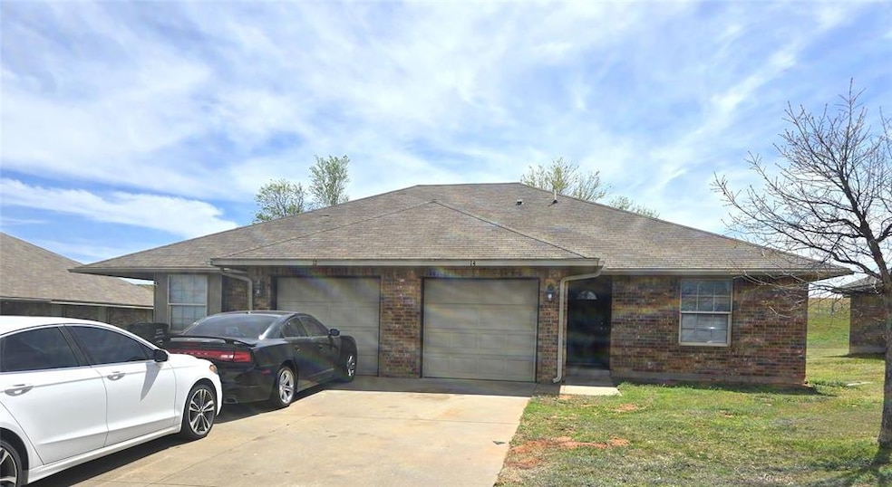 Ranch-style home with driveway, brick siding, a ga