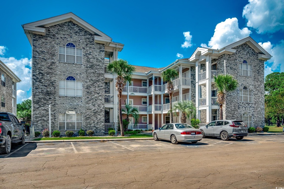 View of apartment building / complex with uncovered parking