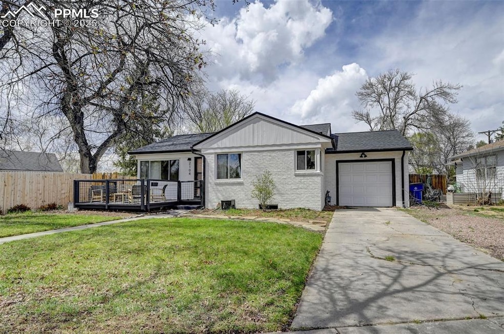 Single story home featuring a deck, fence, a garag