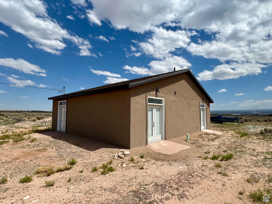 View of home's exterior with stucco siding and french doors