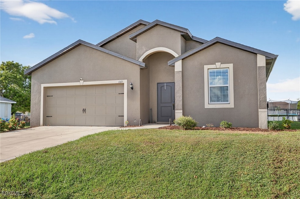 View of front of property featuring a garage, stucco siding, driveway, and a front lawn