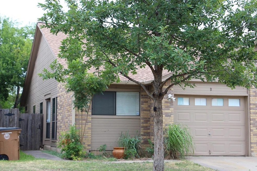 View of front of house featuring a garage, roof w