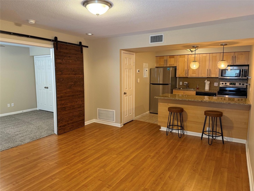 Kitchen featuring a barn door, dark stone counter