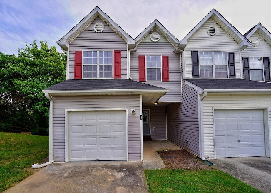 View of front facade featuring an attached garage and asphalt driveway