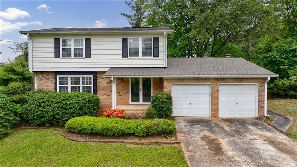 Traditional home with brick siding, a garage, driv
