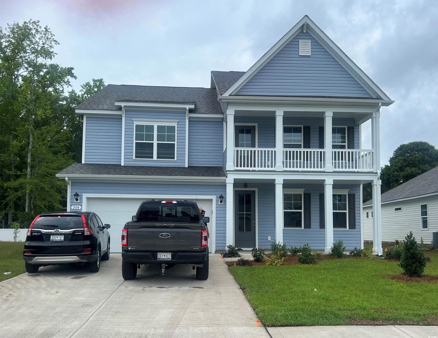 View of front of house with a garage, a balcony, a