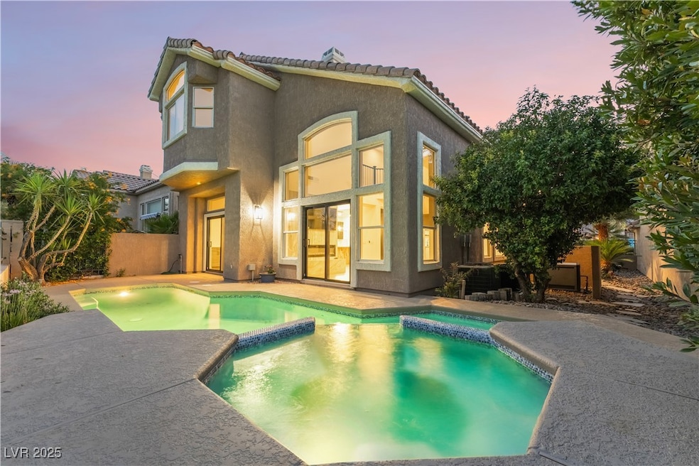 Back of property at dusk with a pool with connecte