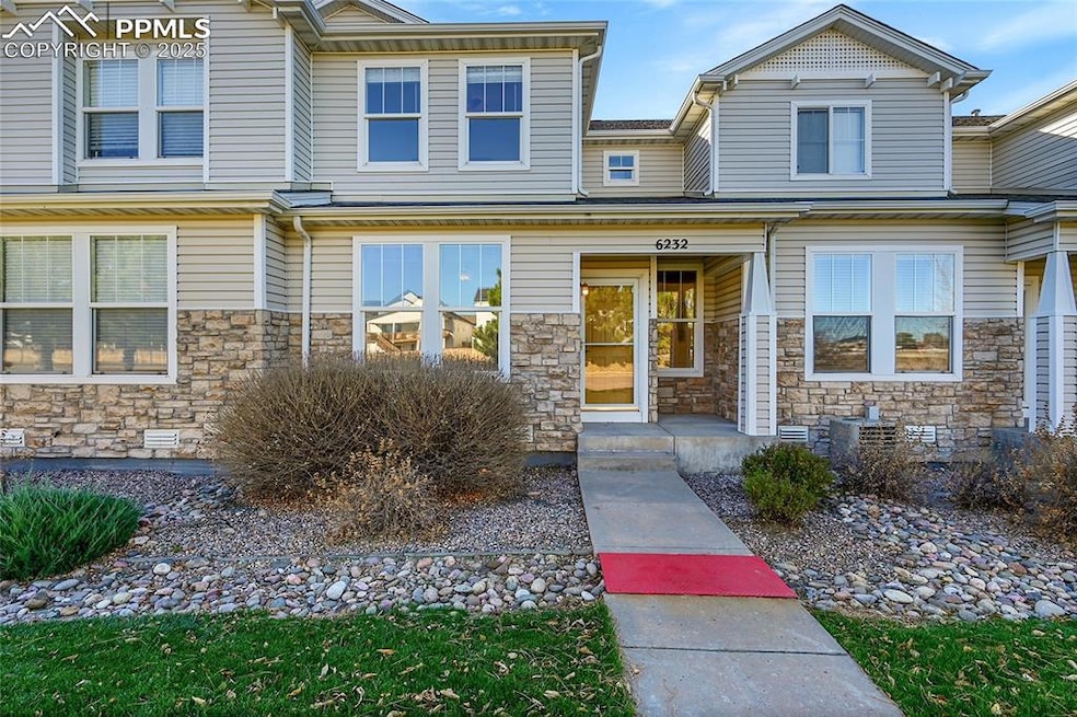 View of front facade with a porch and stone siding