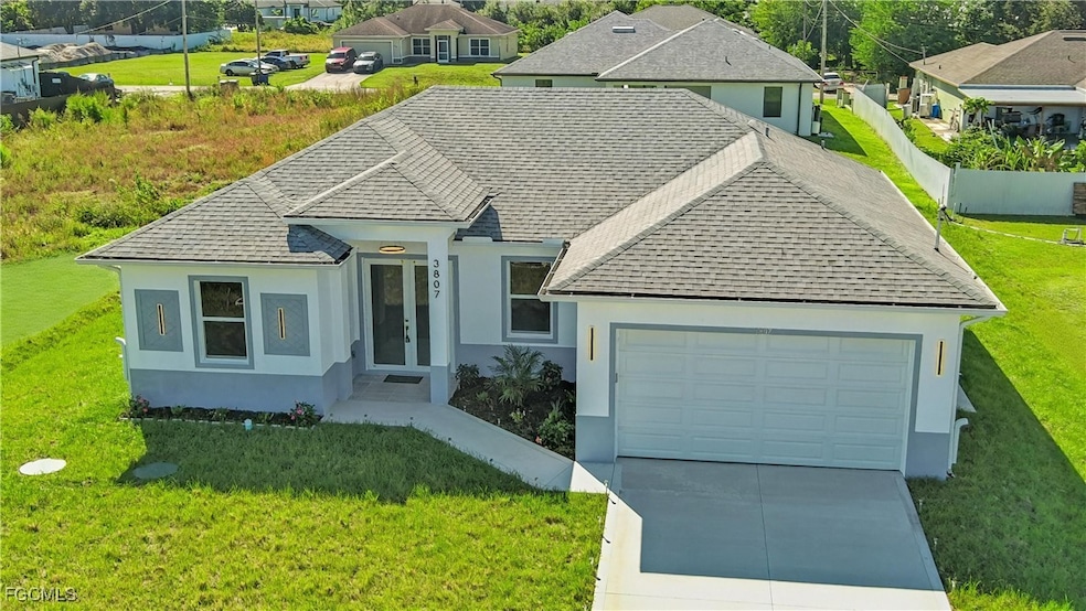 View of front of property with roof with shingles, stucco siding, and a front lawn
