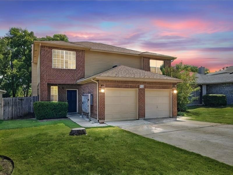 Traditional-style house featuring concrete driveway, a garage, brick siding, and roof with shingles