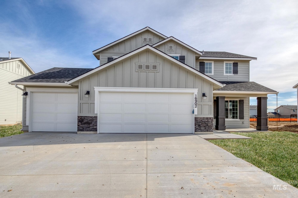 View of front of home with a garage, roof with shingles, driveway, and board and batten siding