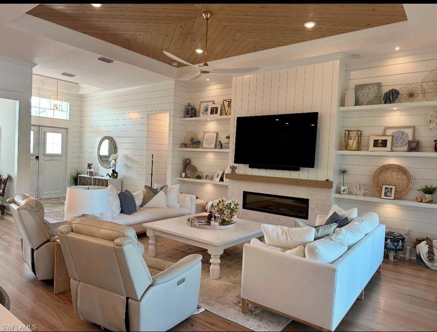 Living room with wood ceiling, wooden walls, and b