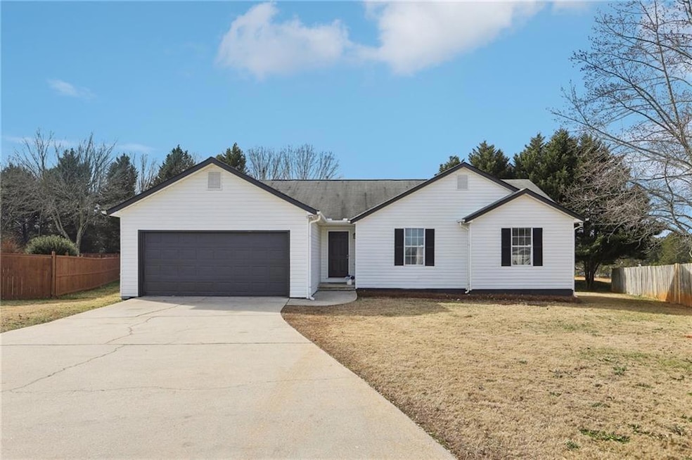 Ranch-style home with a front yard and a garage