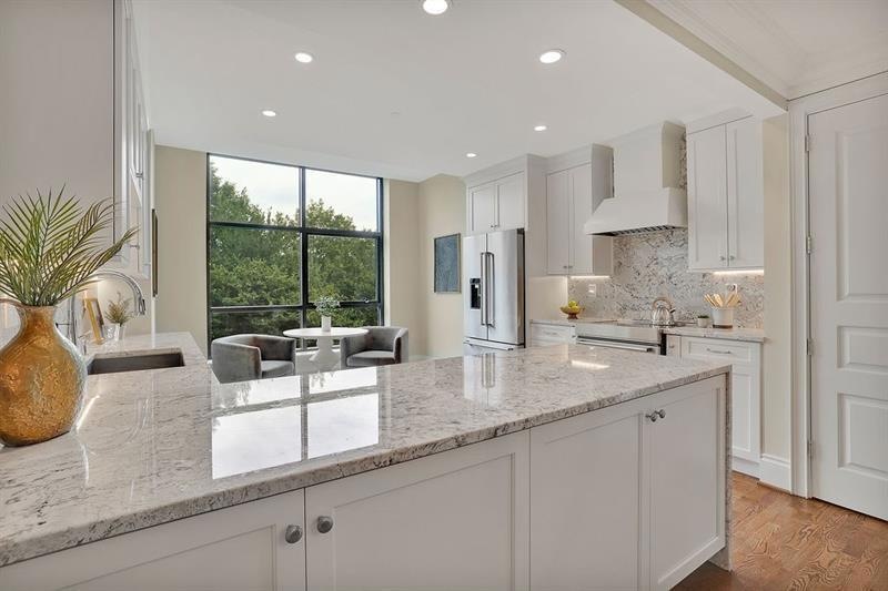 Kitchen featuring white cabinets, custom exhaust h