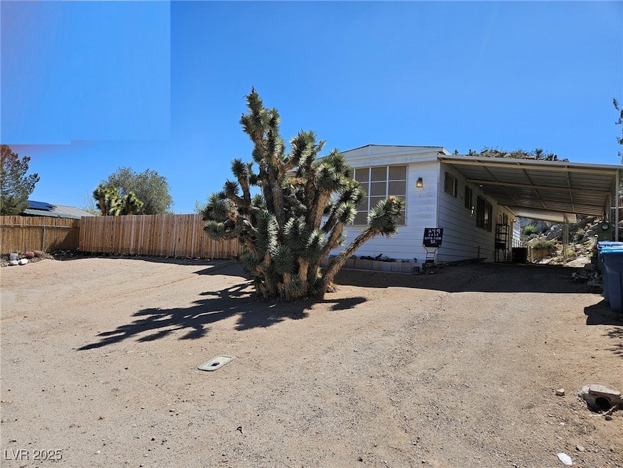 View of yard featuring an attached carport, drivew