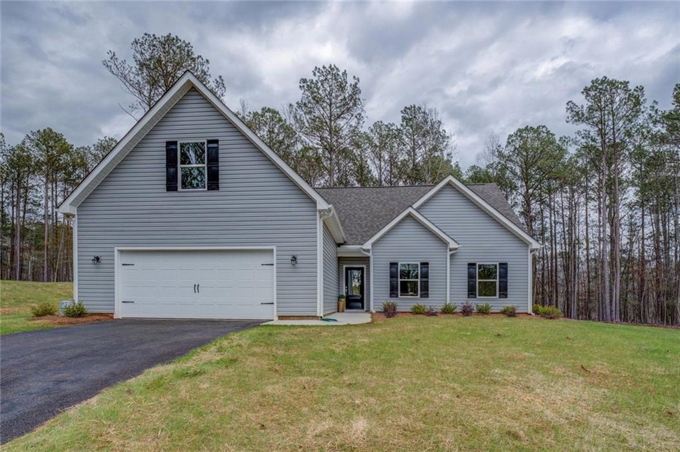 View of front of home with an attached garage, dri