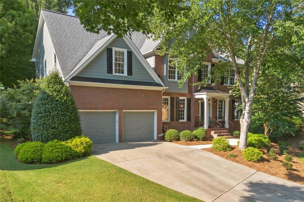 View of front of home with a garage, brick siding, driveway, and a front yard
