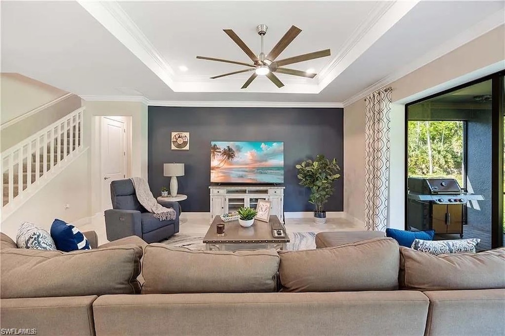 Living room featuring a ceiling fan, a raised ceil