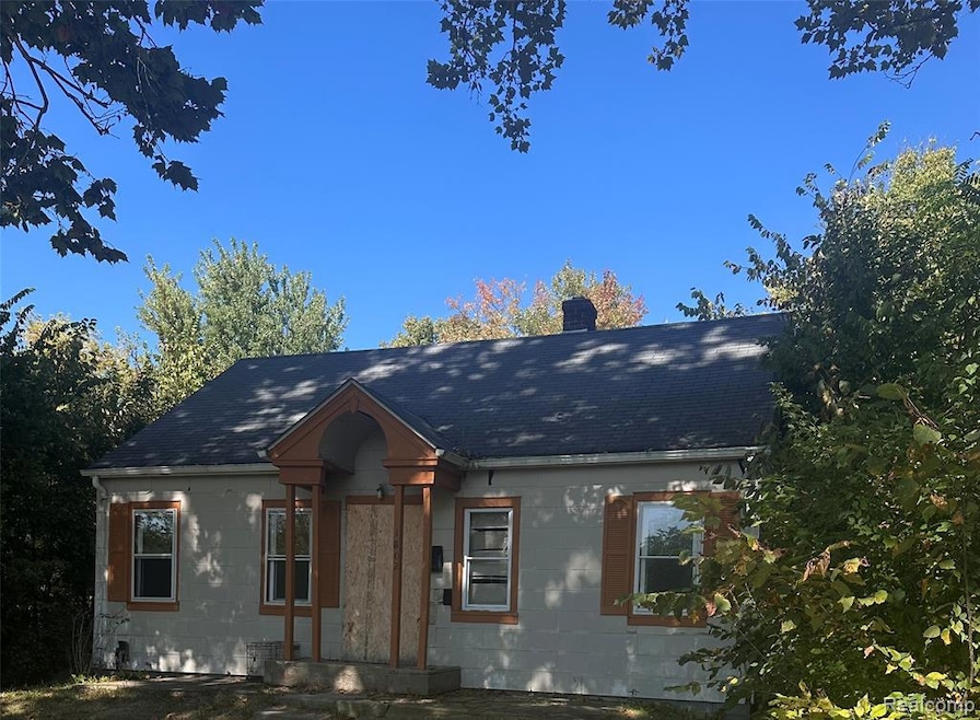 View of front of property featuring a chimney and a shingled roof