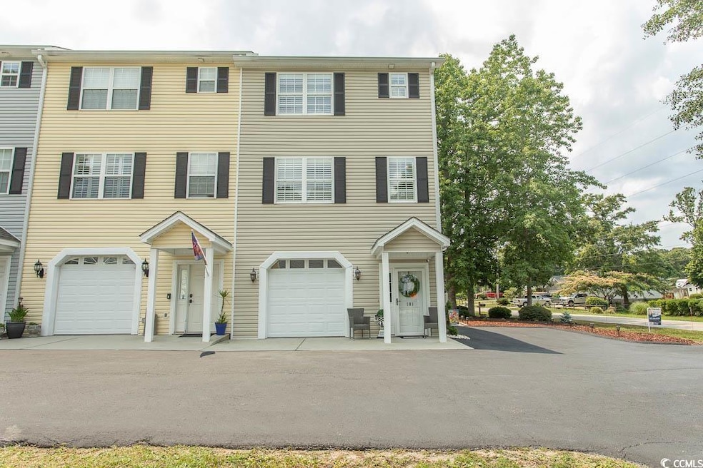 Townhome / multi-family property with an attached garage and asphalt driveway