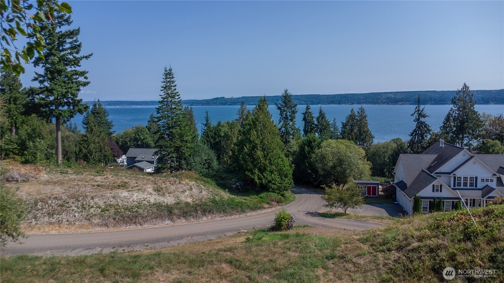 The stunning views of Hood Canal and the Cascade mountains from the potential building site on Lot 2! Power and cable are on the street, water is available, and a connection for the community drain field is located on the parcel where the white house sits on the right.