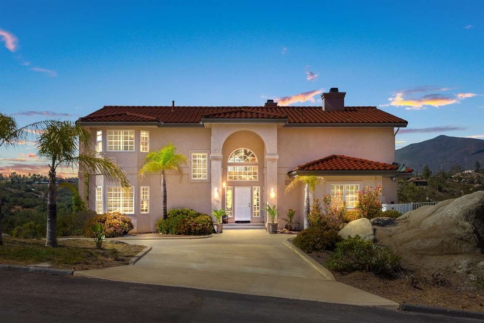 Wrap around driveway and palm trees greet you as y