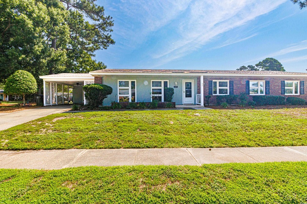 Ranch-style home featuring a carport and a front y