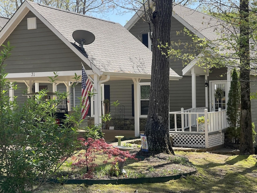 Rear view of house featuring a porch and a shingled roof