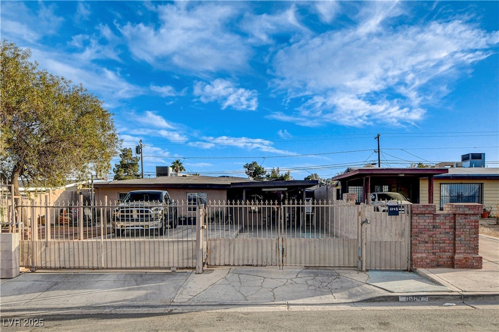 a carport, a fenced front yard, a gate, and stucco