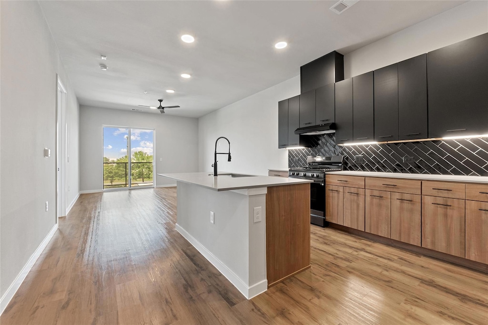 Kitchen with gas stove, a center island with sink