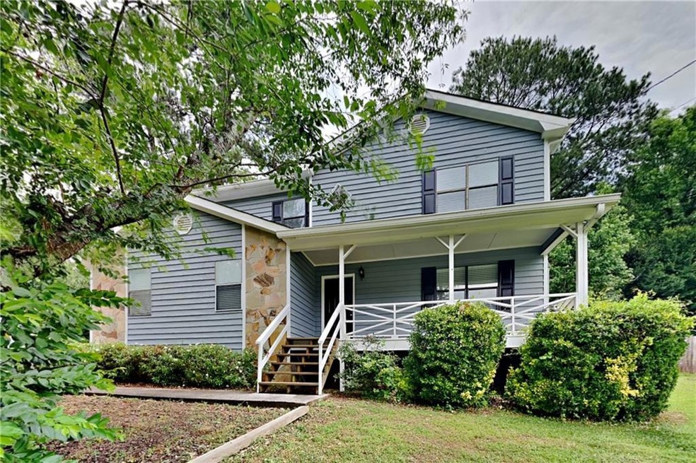 View of front of home with a front lawn and a porc