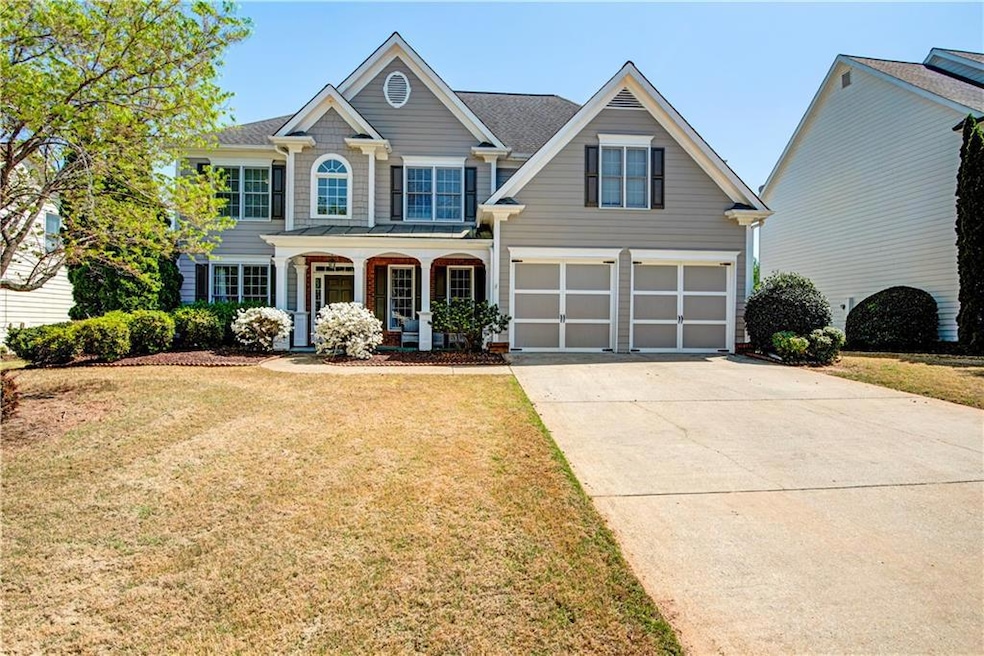 View of front facade with a porch, concrete driveway, a front yard, a shingled roof, and a garage