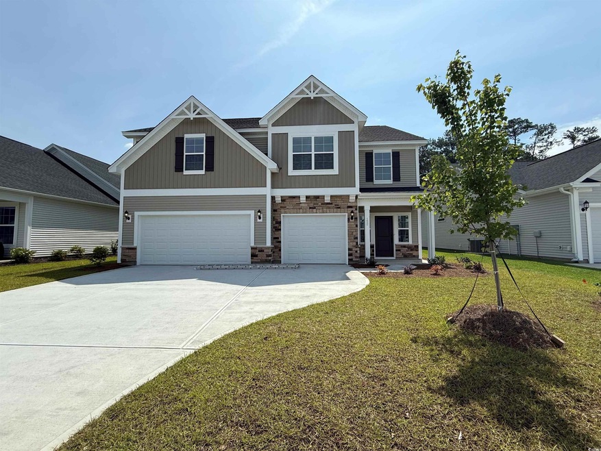 Craftsman house featuring an attached garage, concrete driveway, a front lawn, and stone siding