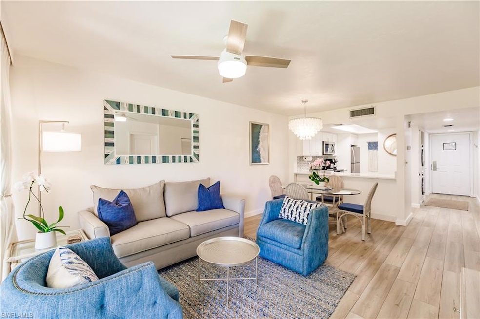 Living room featuring ceiling fan and light wood-t