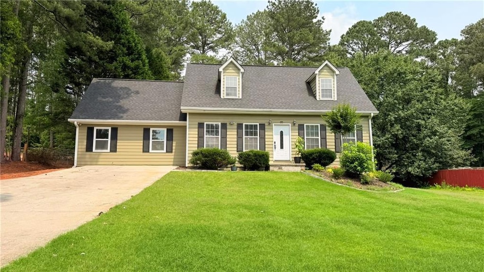 Cape cod house with concrete driveway and a shingled roof