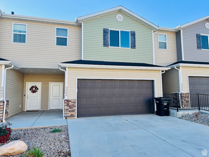View of front of house with concrete driveway, stone siding, and an attached garage
