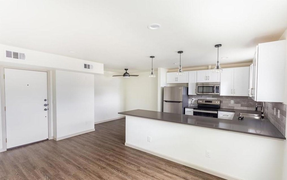 Kitchen with white cabinets, dark countertops, app