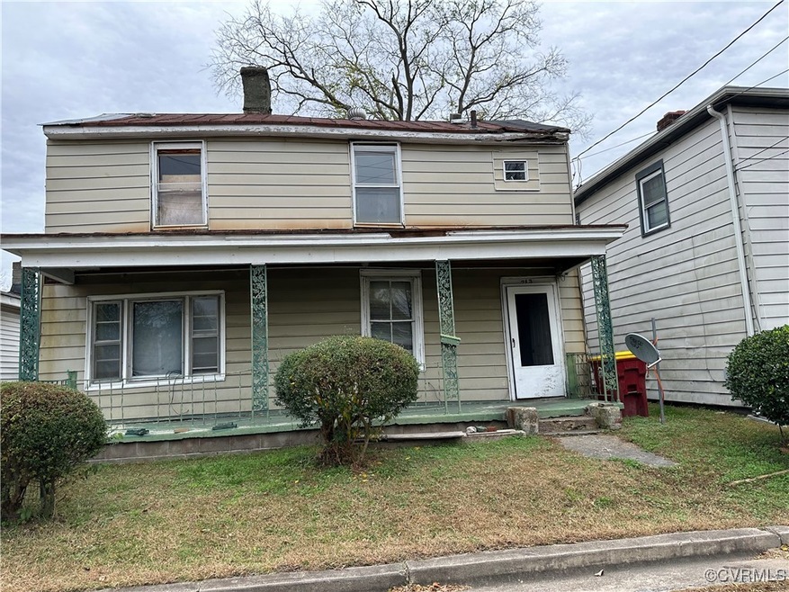 View of front facade with a porch, a chimney, and