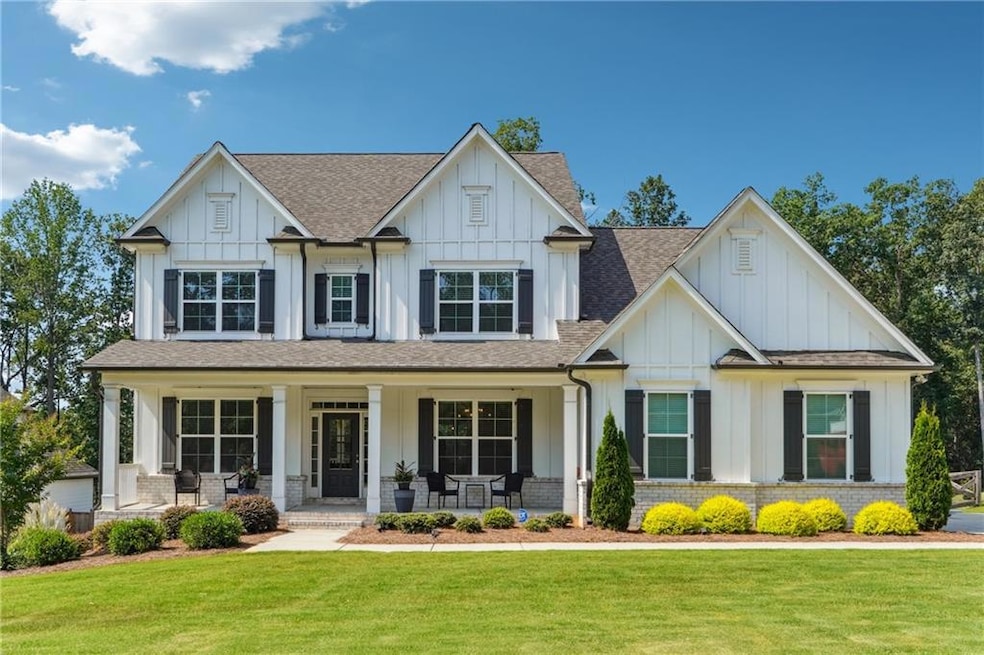 Craftsman house with board and batten siding, a shingled roof, a front yard, and a porch
