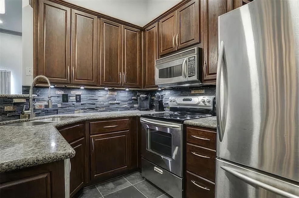 Kitchen with backsplash, dark tile patterned floor
