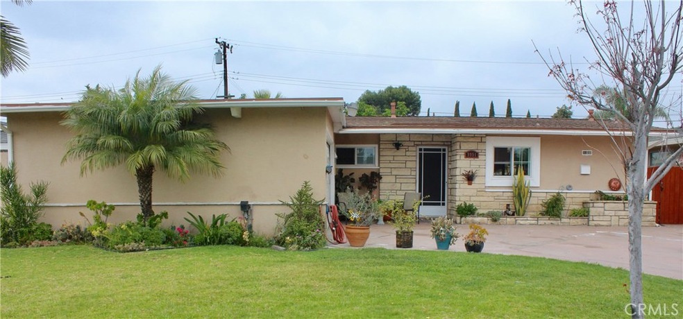 Expansive front yard with mature trees and rose bushes