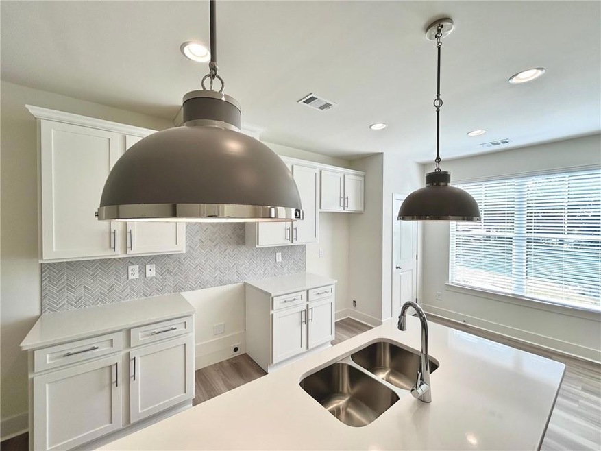 Kitchen featuring hanging light fixtures, sink, li