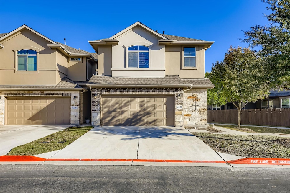 Traditional-style home featuring stone siding, roof with shingles, stucco siding, and concrete driveway