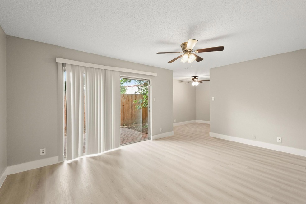 Empty room with a ceiling fan, light wood-style f