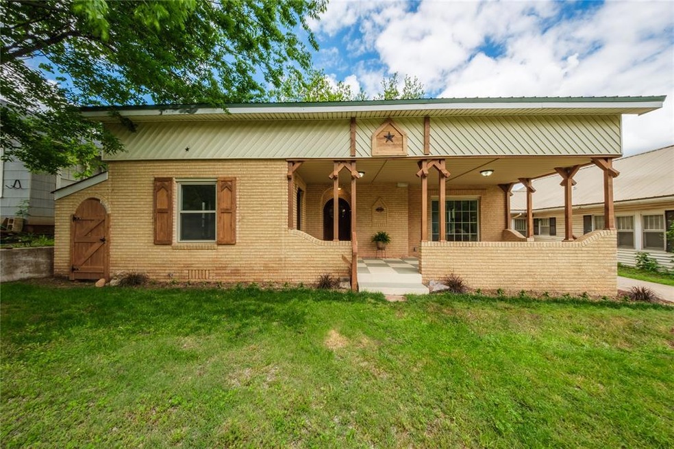 Back of property featuring brick siding, a yard, a
