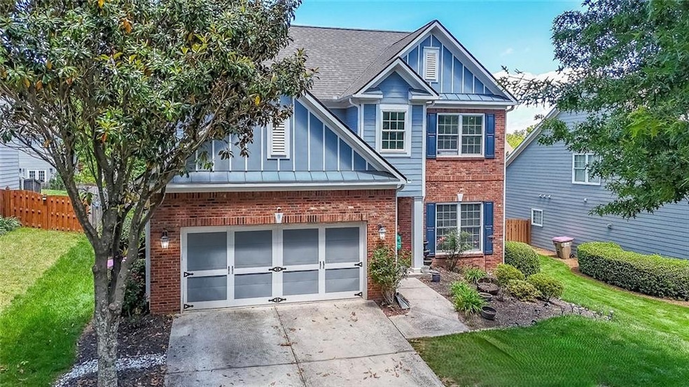 View of front of home with brick siding, driveway, a shingled roof, board and batten siding, and an attached garage